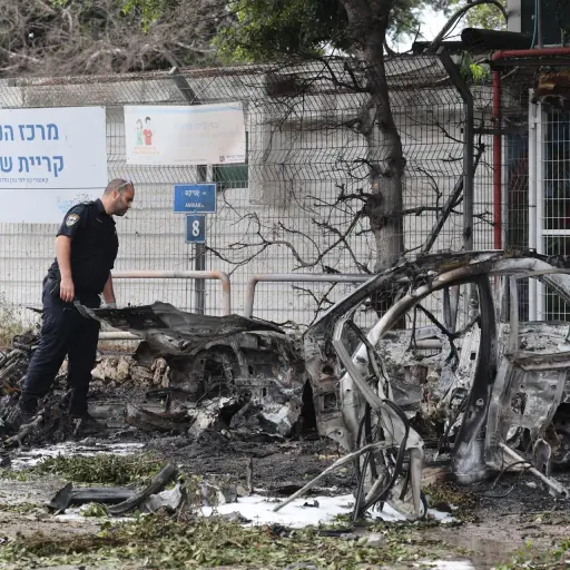 Un policía israelí inspecciona coches calcinados tras el impacto de fragmentos de un misil balístico iraní interceptado en Tel Aviv, Israel, el 15 de marzo de 2026 ,  EFE/EPA/ABIR SULTAN