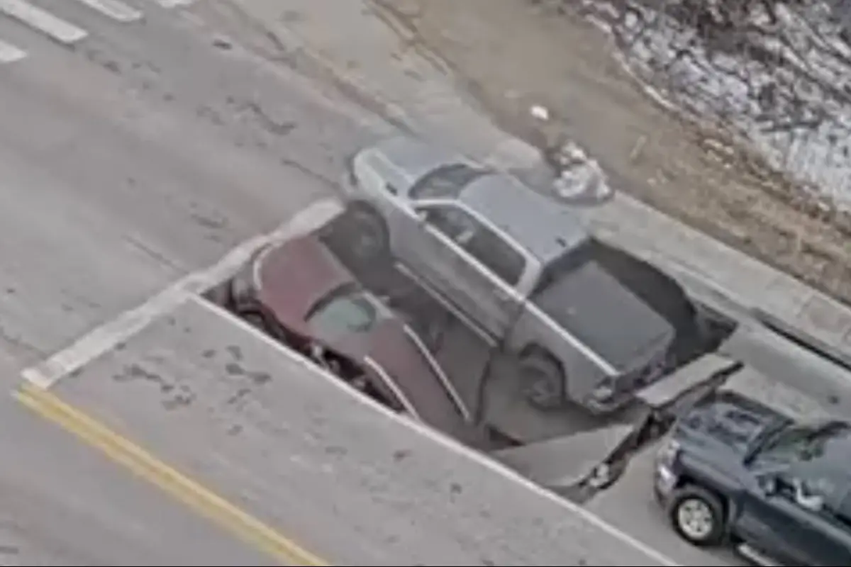 Momento en que dos vehículos caen en socavón mientras esperaban semáforo., Captura de pantalla video de X.