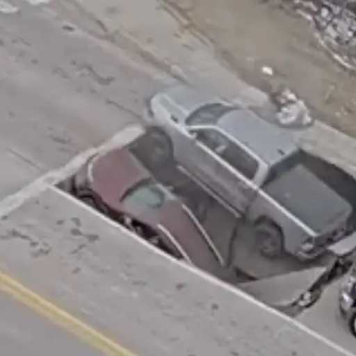 Momento en que dos vehículos caen en socavón mientras esperaban semáforo. ,Captura de pantalla video de X.