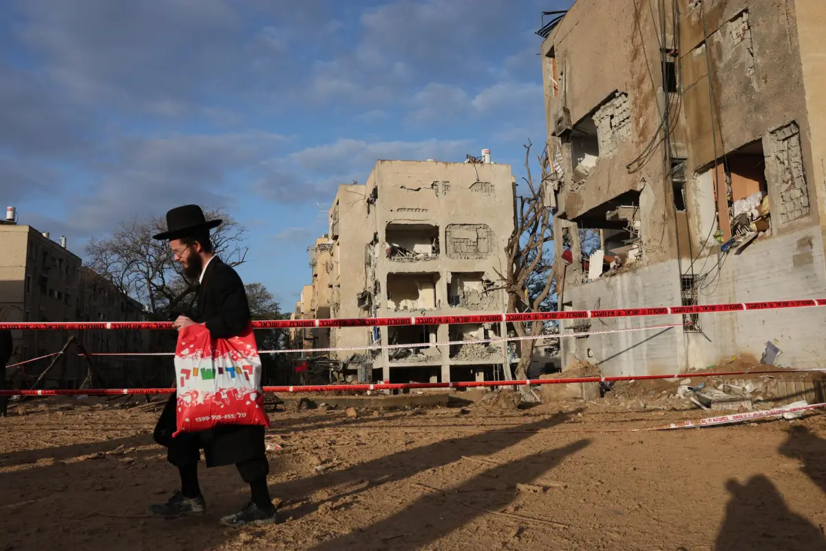 Residentes judíos ultraortodoxos observan la escena del impacto directo de un misil iraní en Arad, Israel, el 22 de marzo de 2026,  EFE/EPA/Abir Sultan
