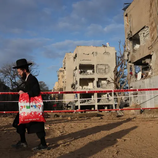 Residentes judíos ultraortodoxos observan la escena del impacto directo de un misil iraní en Arad, Israel, el 22 de marzo de 2026 , EFE/EPA/Abir Sultan