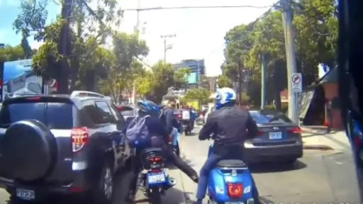 Sin bajarse de sus vehículos, motoristas se van a los golpes en pleno tránsito de zona 10 (VIDEO)