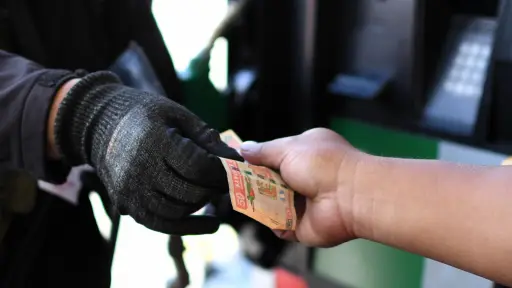 Una persona entrega dinero en una estación de gasolina en Ciudad de Guatemala ,EFE