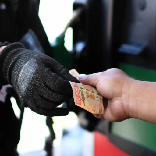 Una persona entrega dinero en una estación de gasolina en Ciudad de Guatemala ,EFE