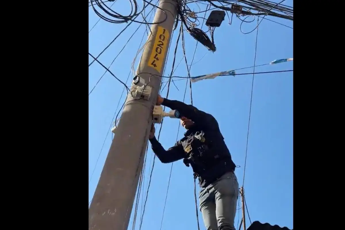 Un integrante de la PNC retira cámaras de videovigilancia vinculadas a pandillas en La Bethania, zona 7., PNC