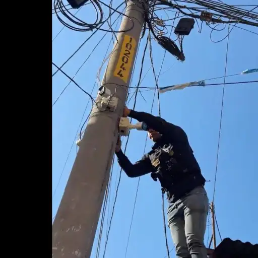 Un integrante de la PNC retira cámaras de videovigilancia vinculadas a pandillas en La Bethania, zona 7. ,PNC