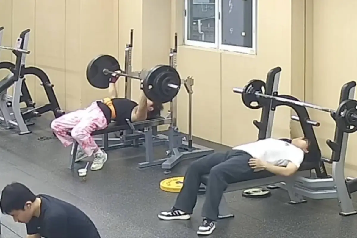 Hombre queda atrapado bajo barra de pesas en gimnasio., Captura de pantalla video de X.
