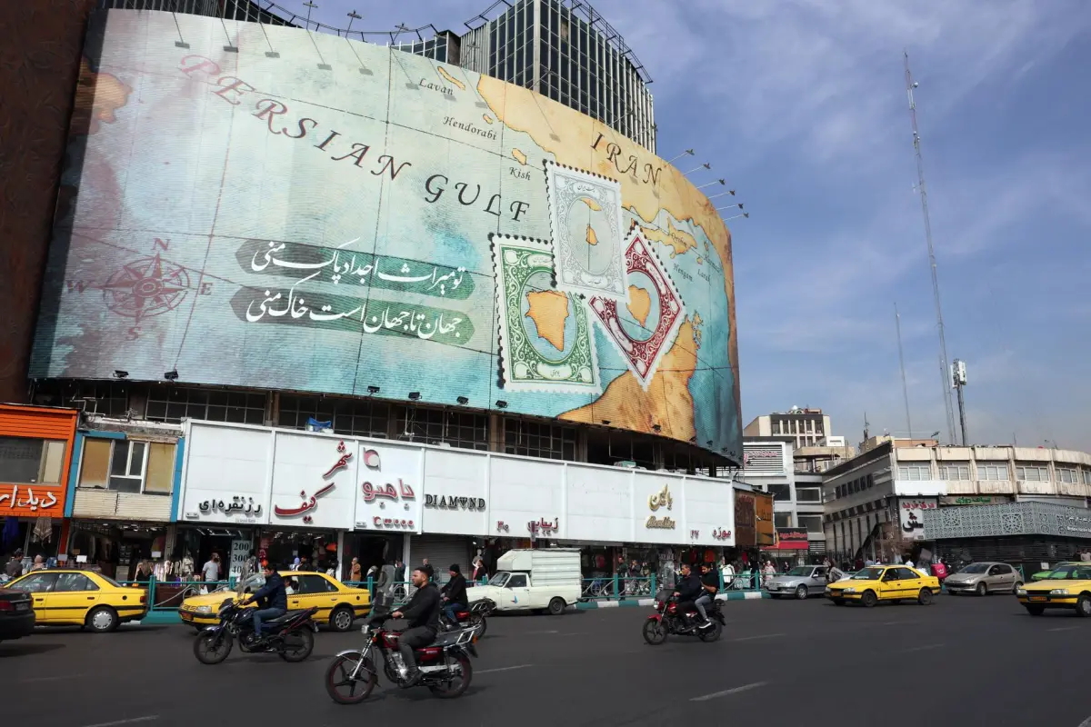 TEHRAN (Iran), - (FILE) - Iraníes pasan por delante de una valla publicitaria que muestra parte del mapa del golfo Pérsico y del estrecho de Ormuz, en Teherán