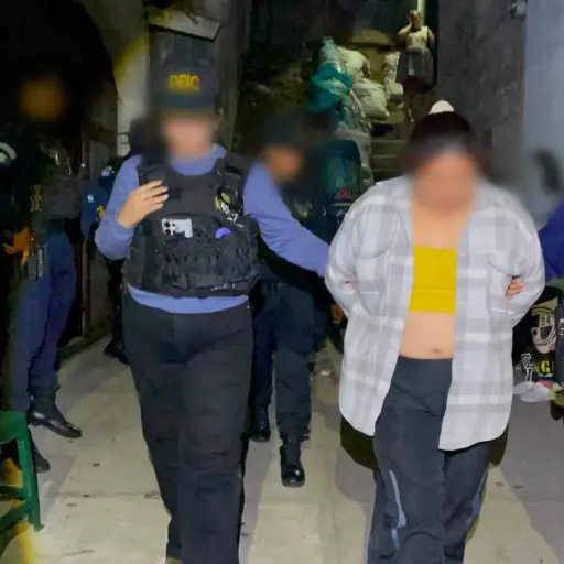 La mujer detenida en el operativo en Sacatepéquez es trasladada por agentes policiales. ,PNC