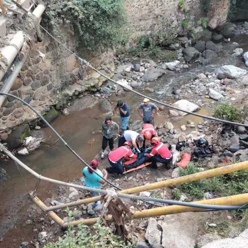 El motorista que cayó bajo el puente fue rescatado por los cuerpos de socorro. ,Bomberos Municipales