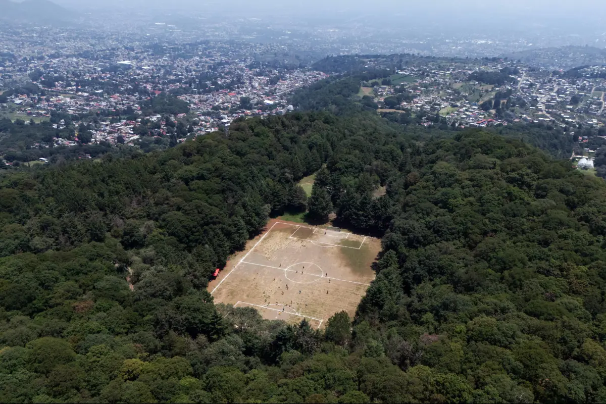 Fotografía aérea que muestra una cancha de fútbol en el cráter de un volcán inactivo este domingo, en Ciudad de México (México). , EFE