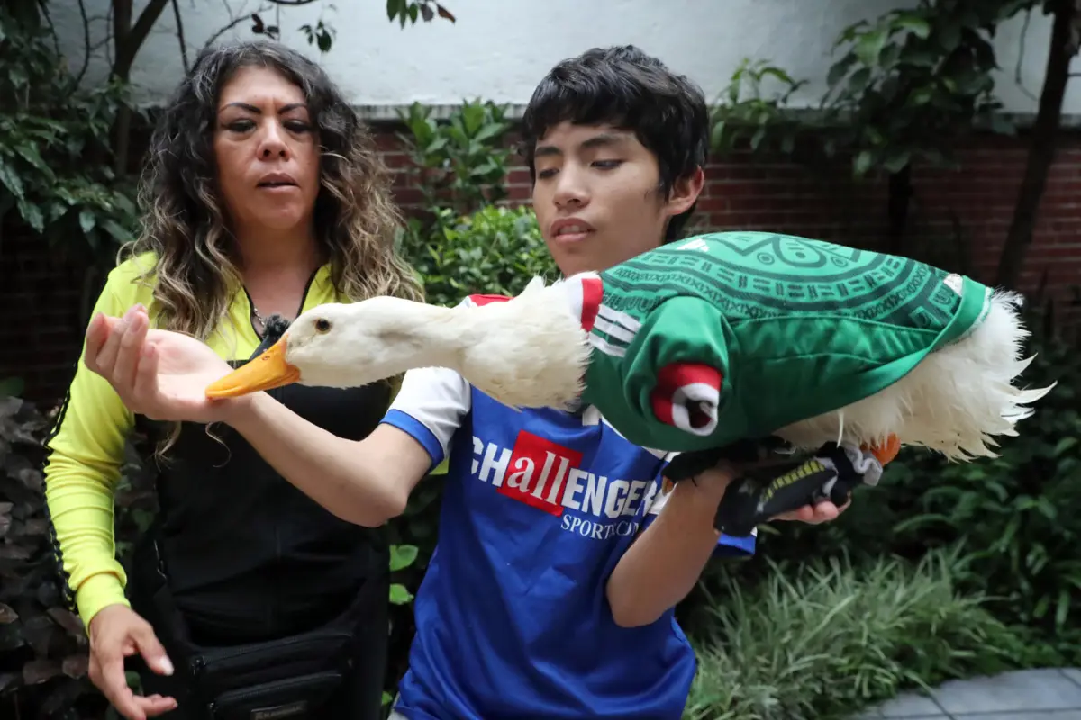 Karla Gómez y su hijo Cristian posando con su pato Merlín., EFE