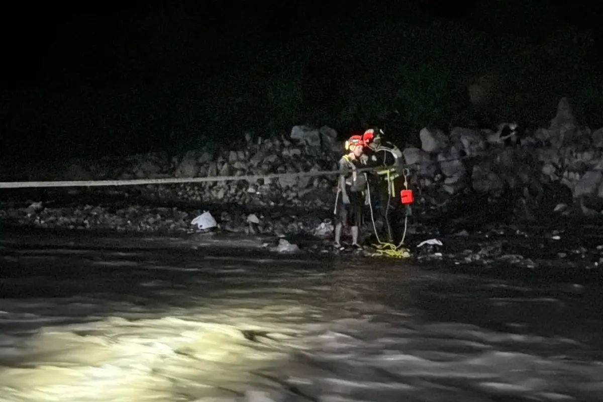 Momento en el que dos personas fueron rescatadas tras quedar atrapadas en la corriente del río Las Vacas, en Chinautla., Bomberos Voluntarios