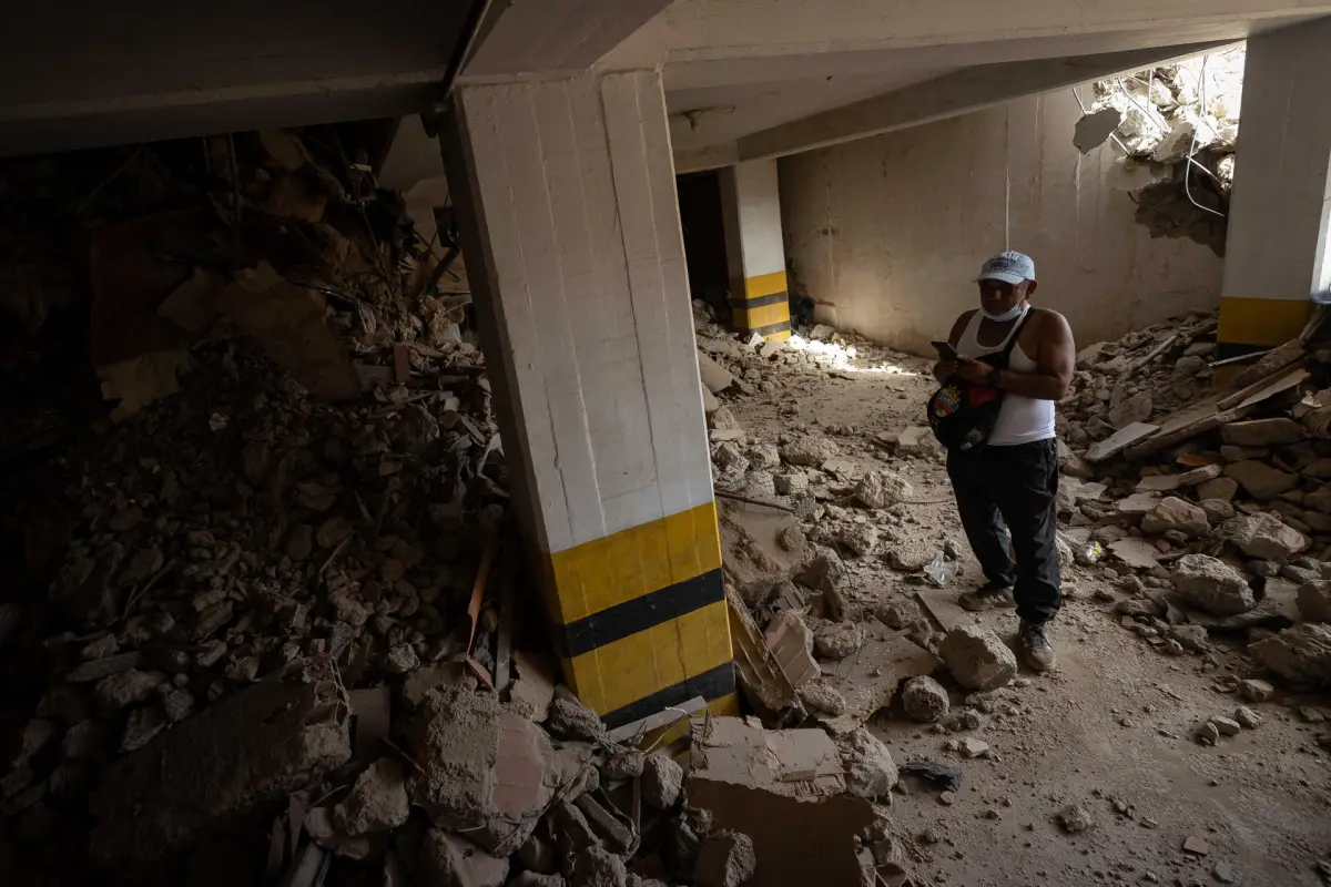 Una persona busca en medio de los escombros de un edificio este domingo, en La Guaira (Venezuela), EFE/ Ronald Peña R