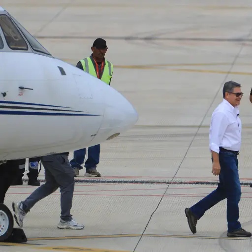 El expresidente hondureño Juan Orlando Hernández (c) (2014-2022) caminando este domingo, a su llegada al Aeropuerto Internacional de Palmerola en Comayagua (Honduras) , EFE/ Gustavo Amador