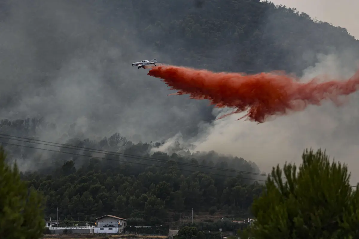 Un avión realiza una descarga con retardante en Betxí en el frente del incendio declarado este sábado en la Vall d'Uixó (Castellón),, EFE/Manuel Bruque