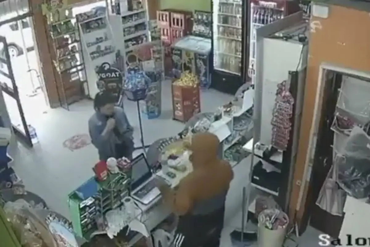 Ladrón atiende a una clienta durante un asalto y le entrega el ticket., Captura de pantalla video de X.