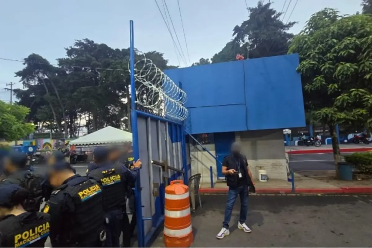 Agentes de la PNC resguardan el portón del ingreso a la USAC durante los allanamientos., Ministerio Público.