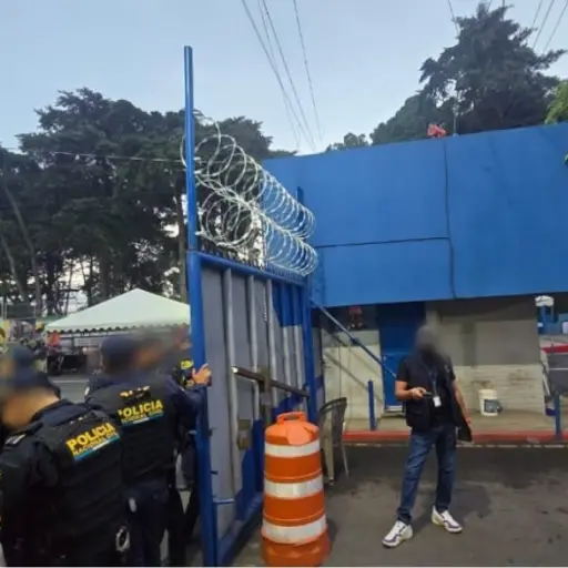 Agentes de la PNC resguardan el portón del ingreso a la USAC durante los allanamientos. ,Ministerio Público.