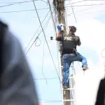 Varios agentes suben a lo alto de los postes para retirar las cámaras instaladas sin autorización. ,PNC de Guatemala.