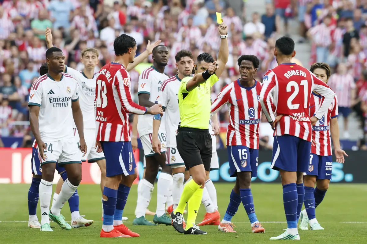 El árbitro Miguel Ángel Ortiz saca tarjeta amarilla al jugador del Atlético de Madrid Cuti Romero