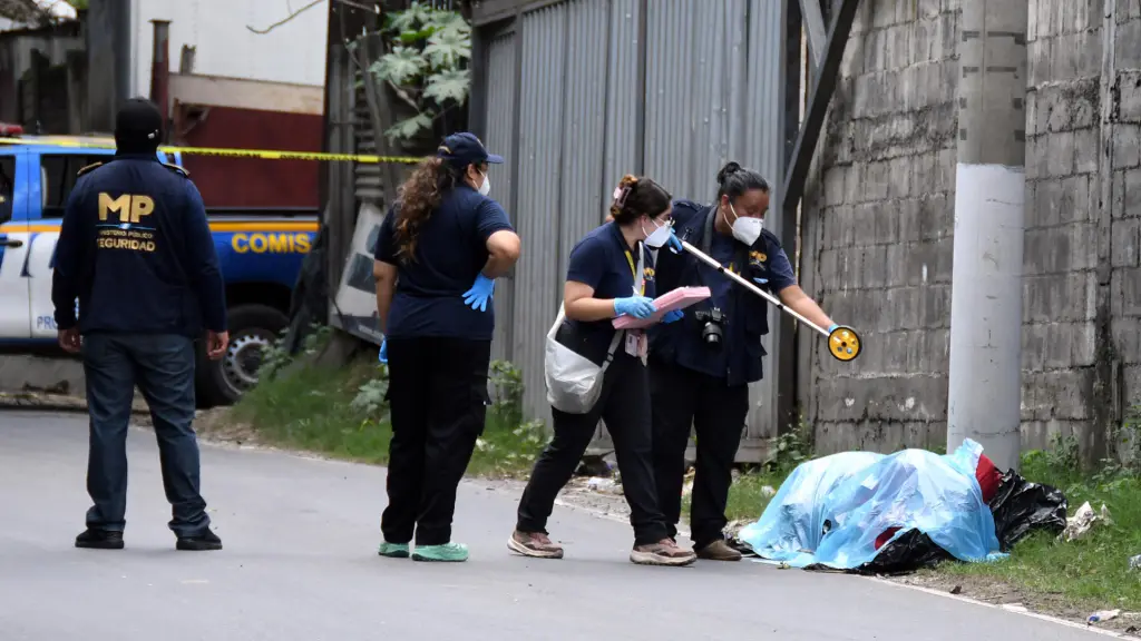 Fotografía que muestra a integrantes del Ministerio Público y de la Policía Nacional Civil inspeccionando dos cadáveres encontrados en bolsas plásticas y amarrados con lazos a un costado de la carretera antigua que conduce a Chinautla (Guatemala) , EFE/ Alex Cruz