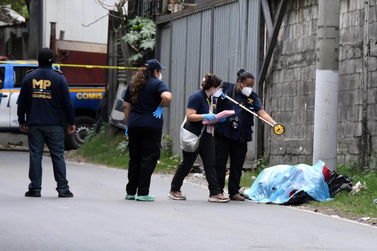 Fotografía que muestra a integrantes del Ministerio Público y de la Policía Nacional Civil inspeccionando dos cadáveres encontrados en bolsas plásticas y amarrados con lazos a un costado de la carretera antigua que conduce a Chinautla (Guatemala), EFE/ Alex Cruz