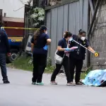 Fotografía que muestra a integrantes del Ministerio Público y de la Policía Nacional Civil inspeccionando dos cadáveres encontrados en bolsas plásticas y amarrados con lazos a un costado de la carretera antigua que conduce a Chinautla (Guatemala) , EFE/ Alex Cruz
